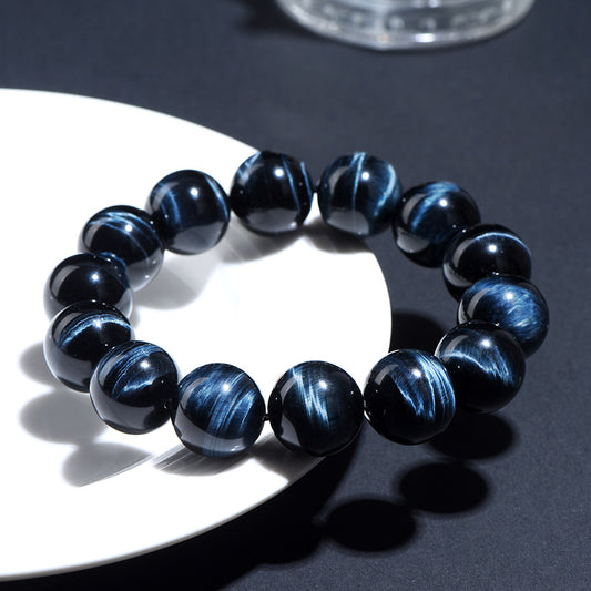 Blue tiger’s eye beaded bracelet with glossy striped stones in sunlight