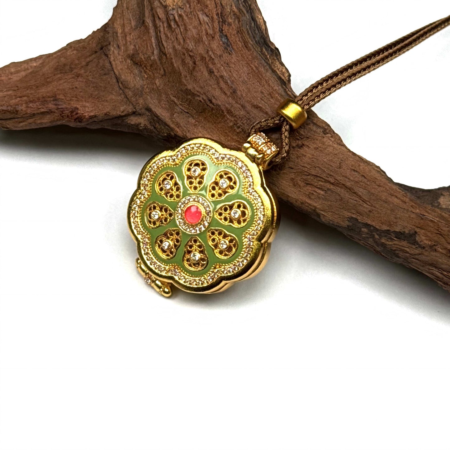 An opened golden Buddha locket amulet resting on natural driftwood, highlighting the hidden deity and exquisite craftsmanship inside.