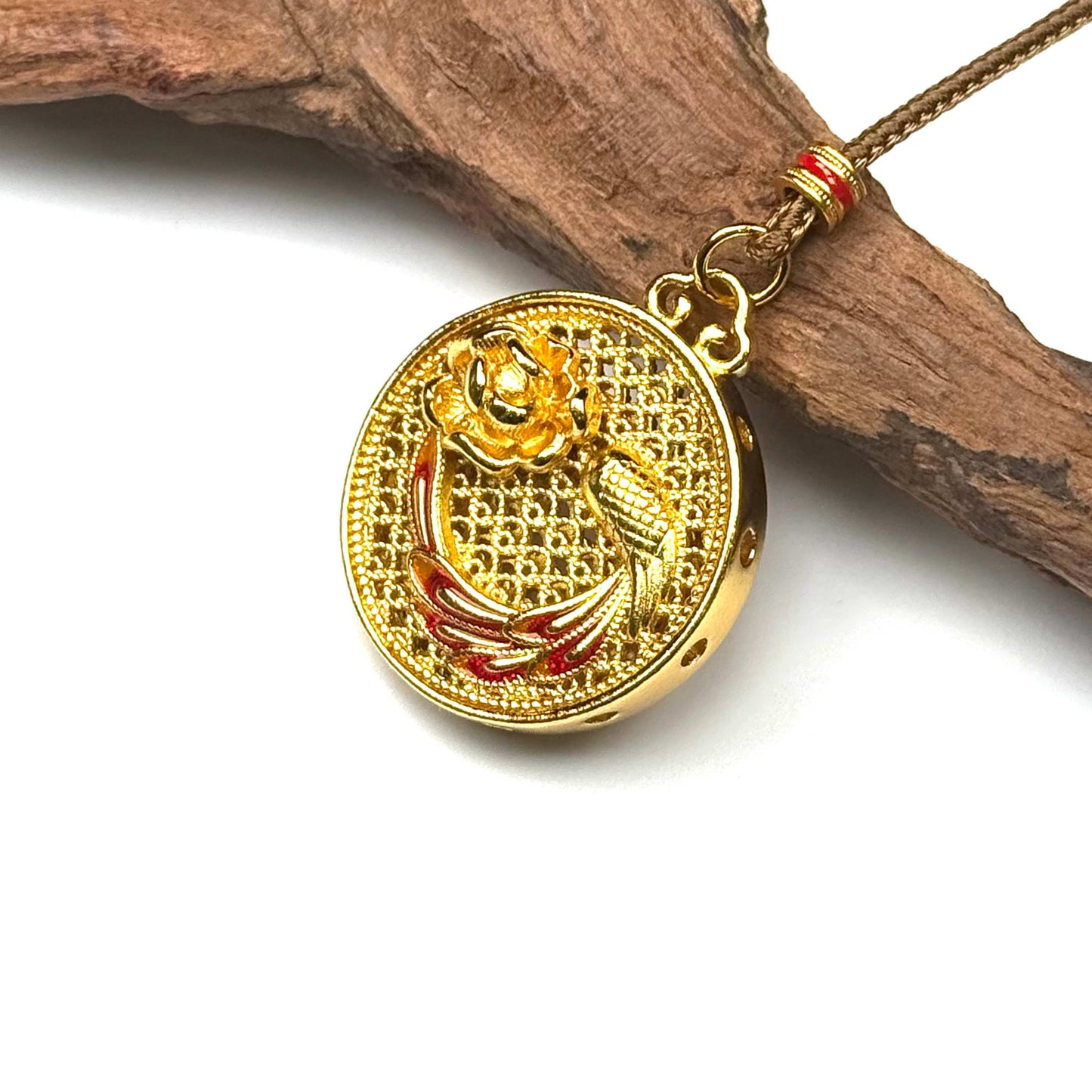 Macro shot of a sand gold filigree prayer gourd necklace on wood, capturing the precise red enamel core inside the hollow globe.