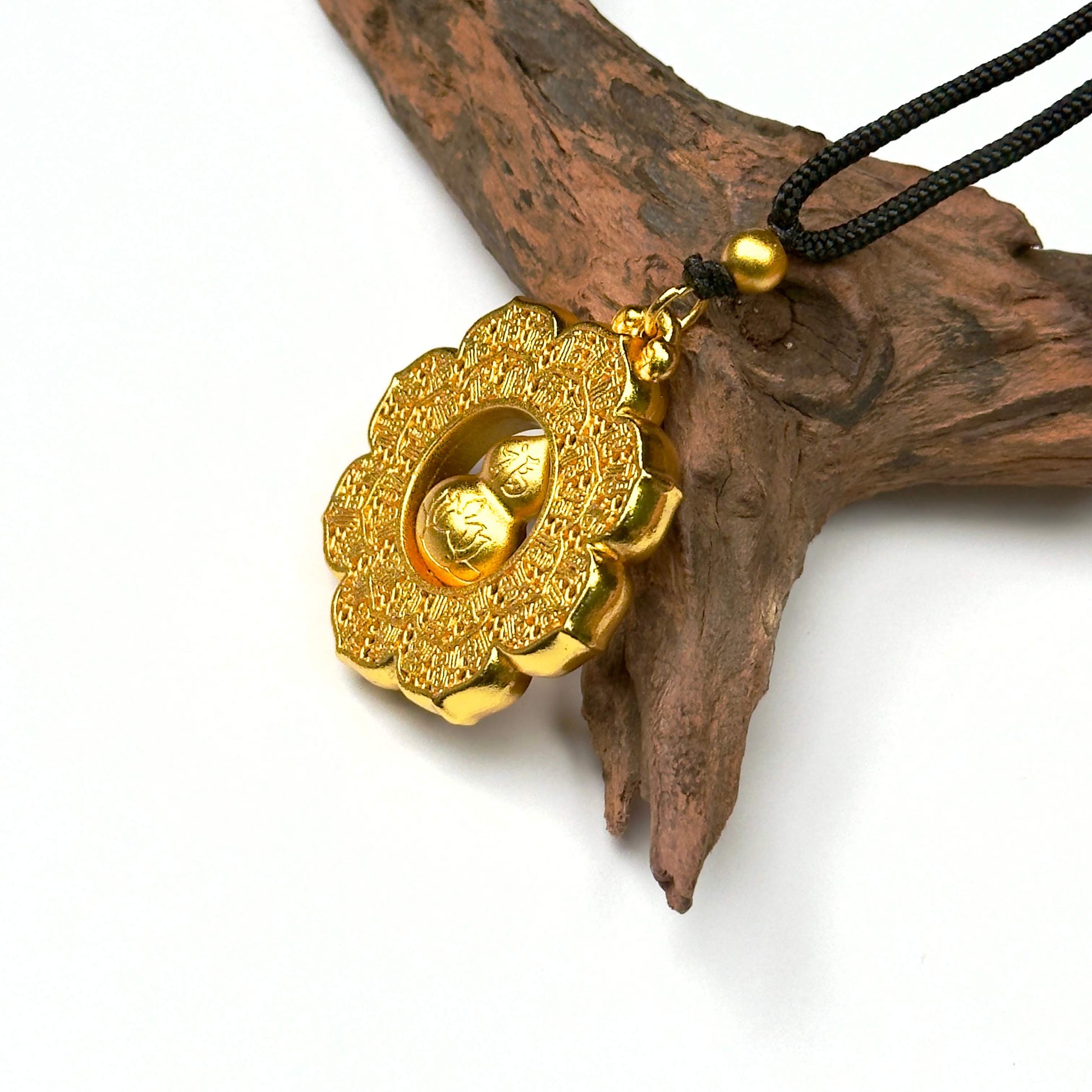 Macro close-up shot of the spinning sand gold Hulu locket on wood, showing the reverse side engraved lotus flower mid-turn.