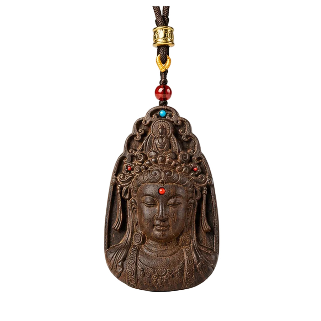 Front view of an agarwood Guanyin pendant with dark braided cord and red accent bead