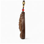 Side view showing the one-centimeter thickness of an agarwood Guanyin pendant