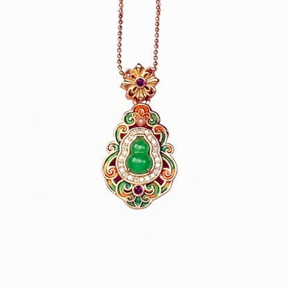 A crisp front view of an authentic sand gold Hulu gourd pendant featuring a central translucent green chalcedony stone, colorful enamel leaf motifs, and a brilliant rhinestone border on a white background.