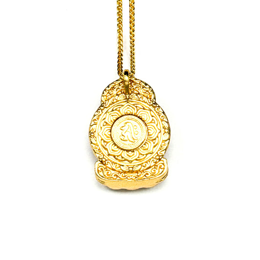 The intricately carved back side of a gold Buddha pendant, revealing a stunning lotus mandala design with a central Sanskrit seed syllable on a white background.