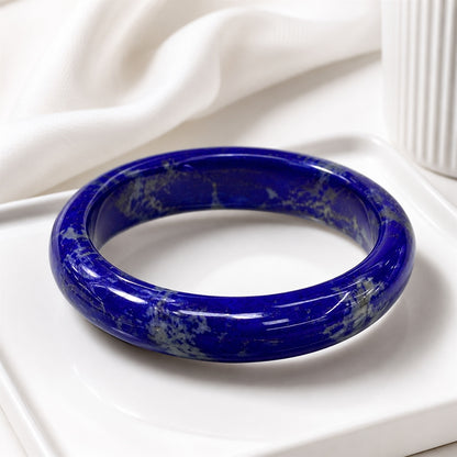 Deep blue lapis lazuli bangle displayed on a white tray
