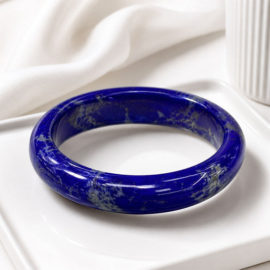 Deep blue lapis lazuli bangle displayed on a white tray