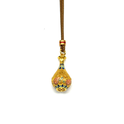 A front-view close-up of a Vietnam sand gold vase pendant, featuring intricate pink and blue enamel floral designs and a coin motif at the base, displayed against a pure white background.