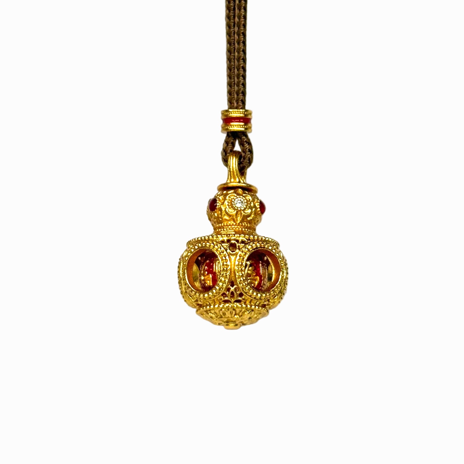 The detailed side-front view of a gold filigree Hulu gourd amulet, highlighting the circular cut-out windows and intricate hollow latticework.
