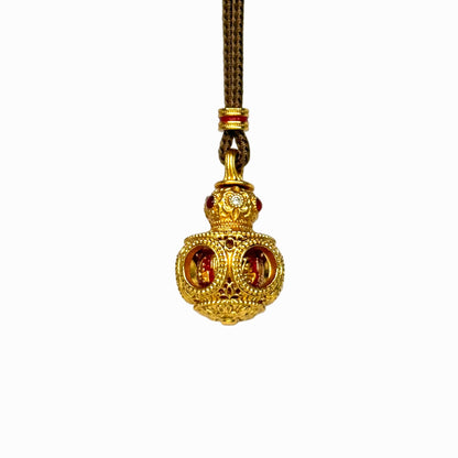 The detailed side-front view of a gold filigree Hulu gourd amulet, highlighting the circular cut-out windows and intricate hollow latticework.