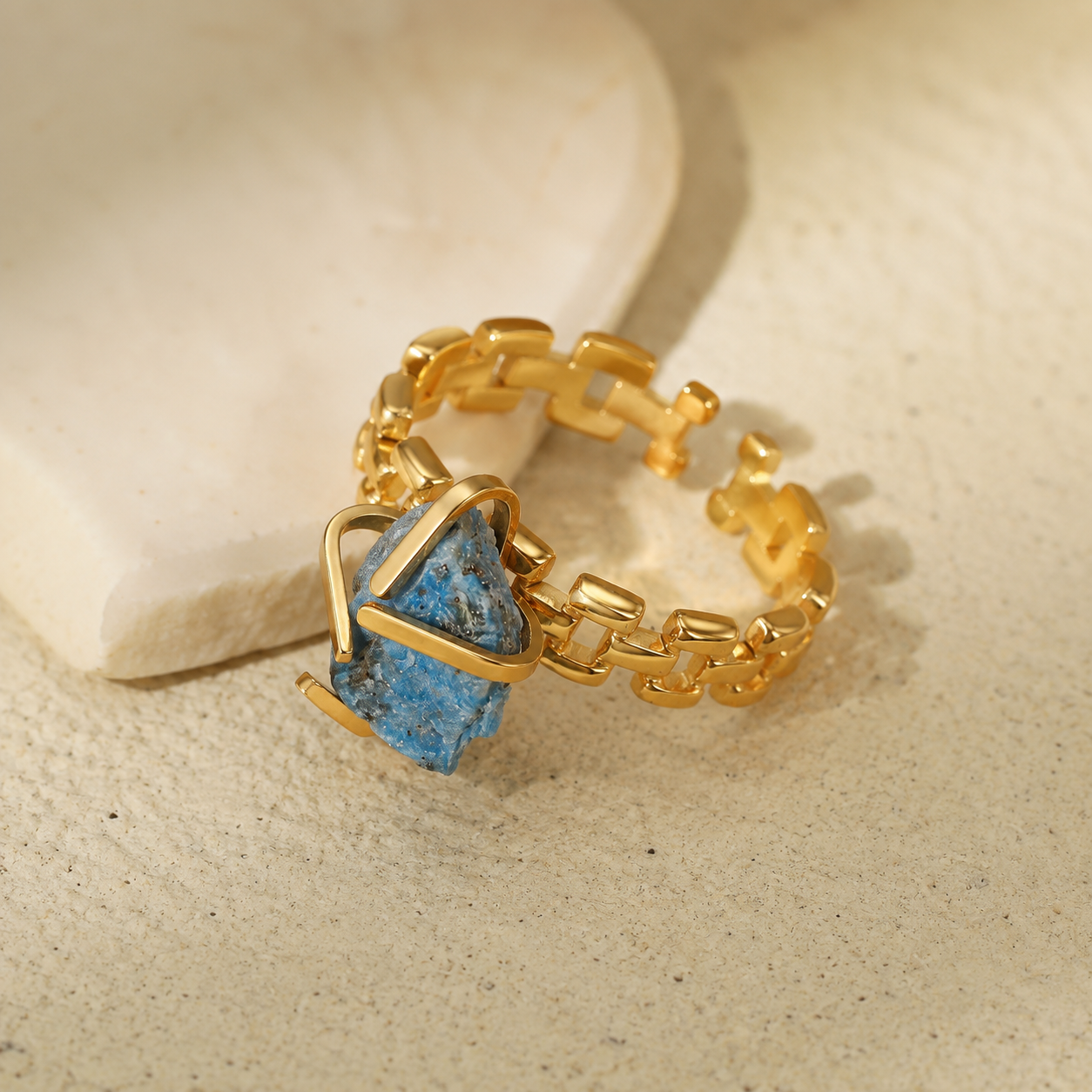 Gold-plated stainless steel chain-link ring with an irregular blue stone centerpiece