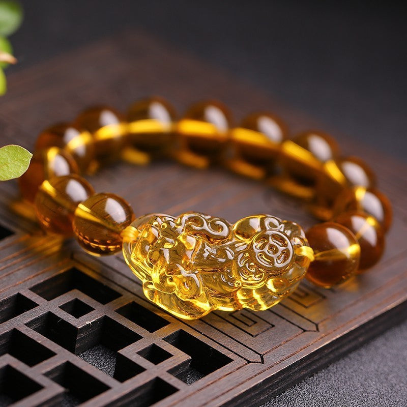 Close-up of golden Pixiu charm on citrine beaded bracelet