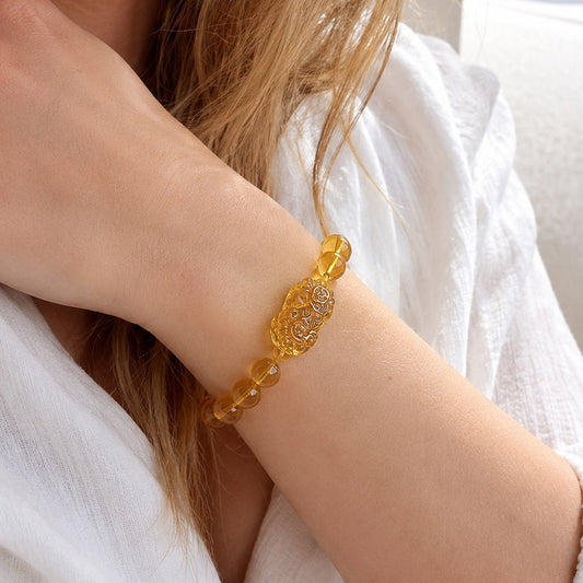 Golden Pixiu citrine bracelet worn on wrist with white outfit