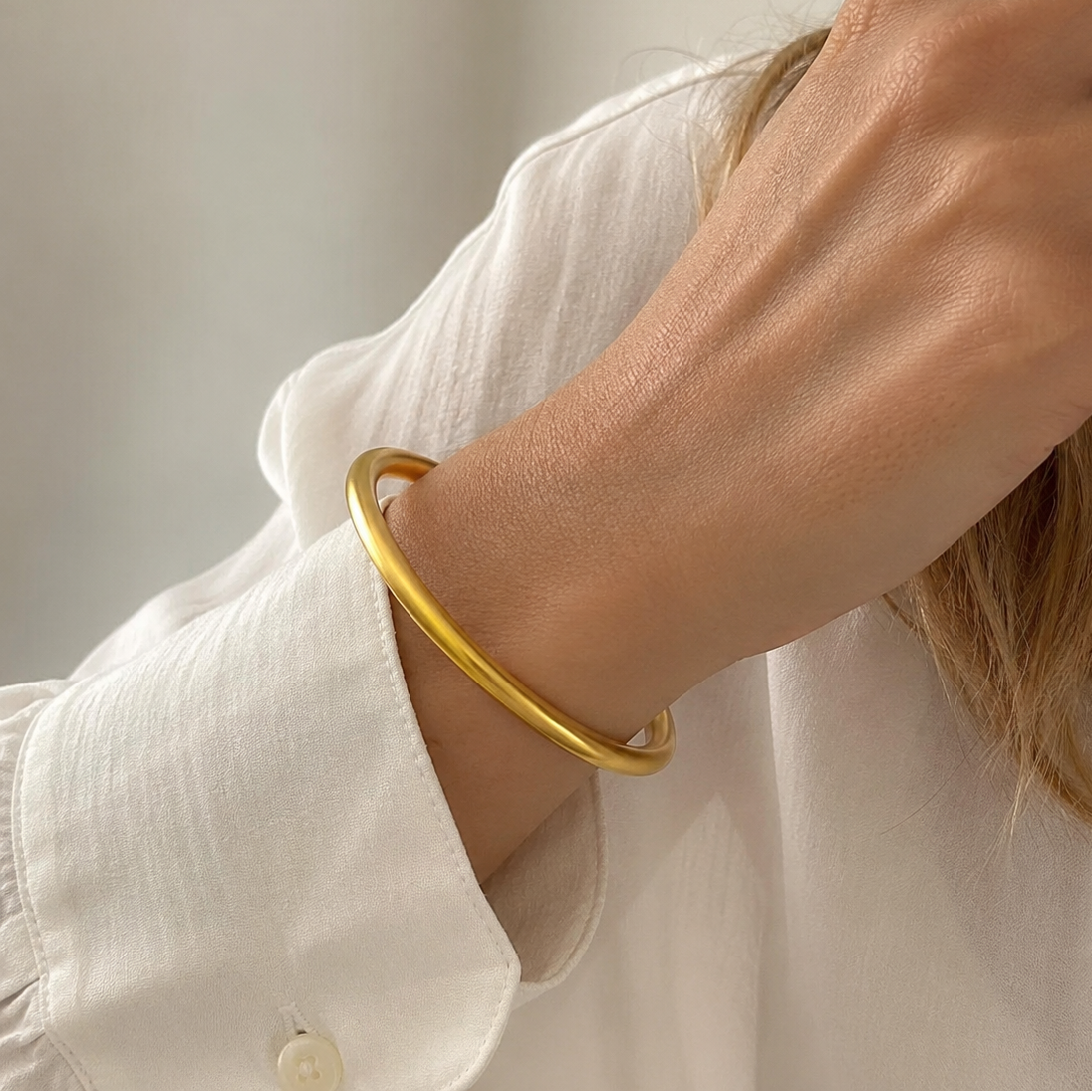 shirt.webp
Minimalist sandgold bangle worn on wrist with white shirt
