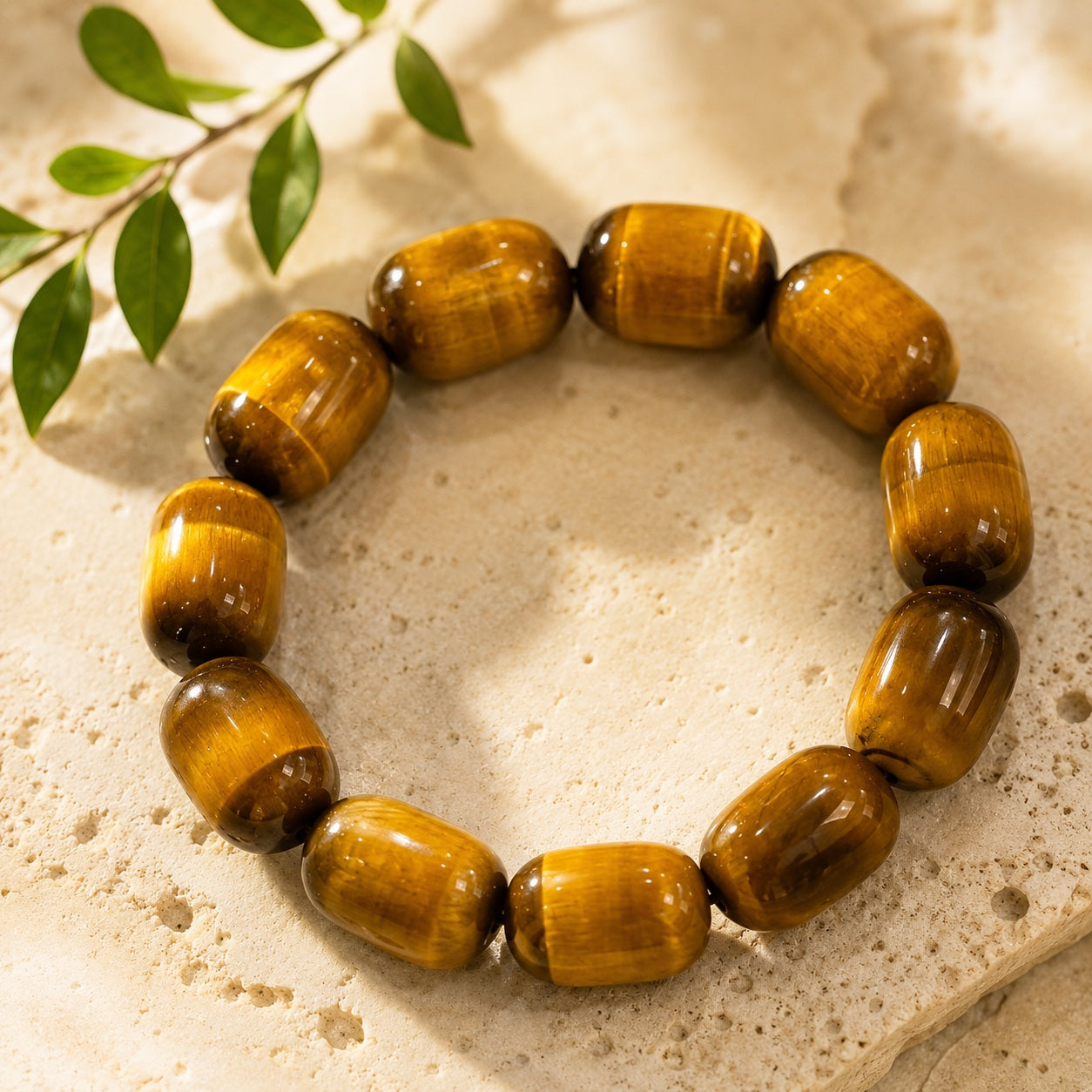 Golden tiger’s eye barrel bead bracelet displayed on a neutral stone surface