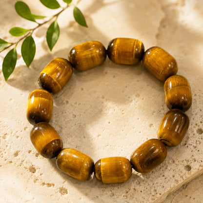 Golden tiger’s eye barrel bead bracelet displayed on a neutral stone surface