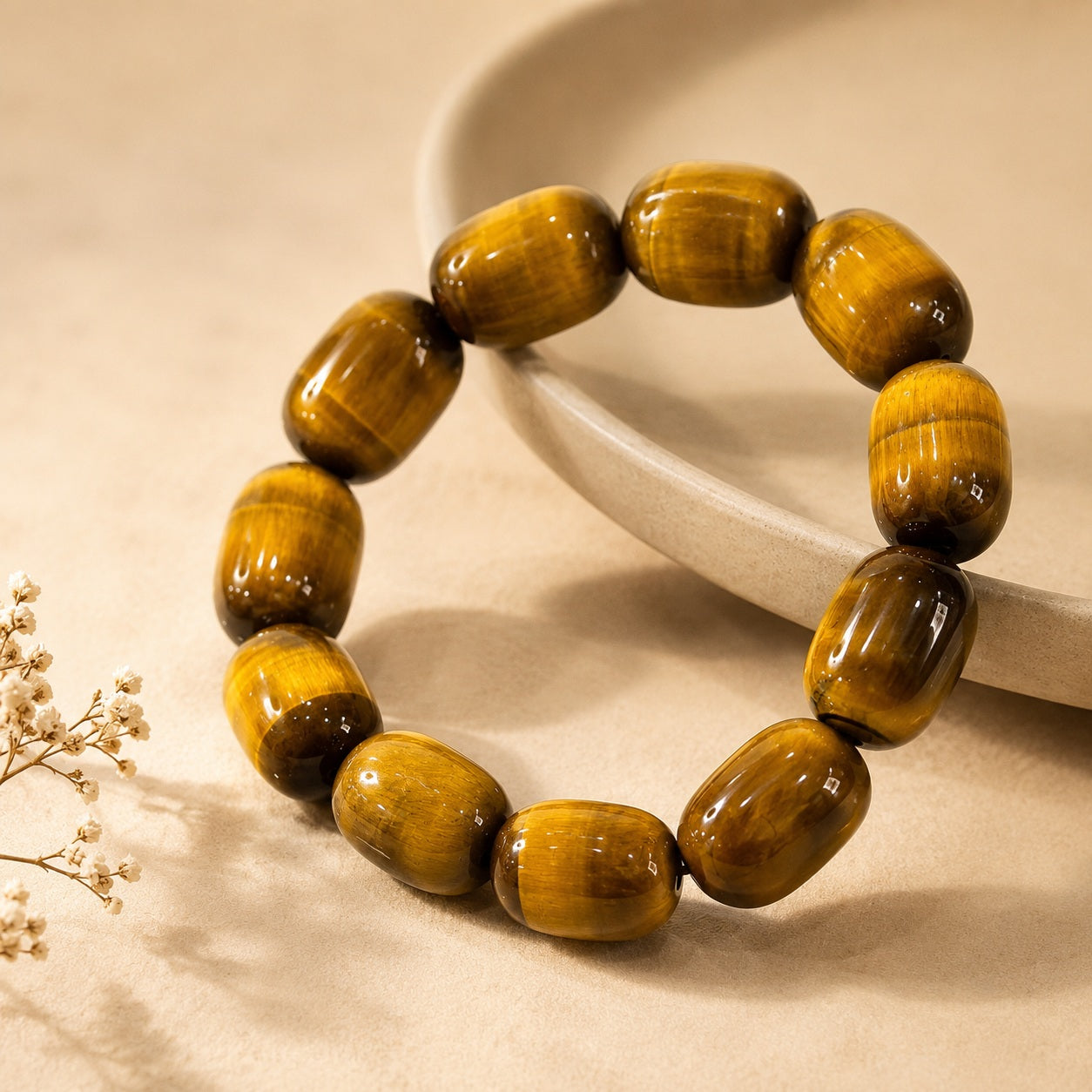 Polished golden tiger’s eye barrel bead bracelet in a soft neutral product setting
