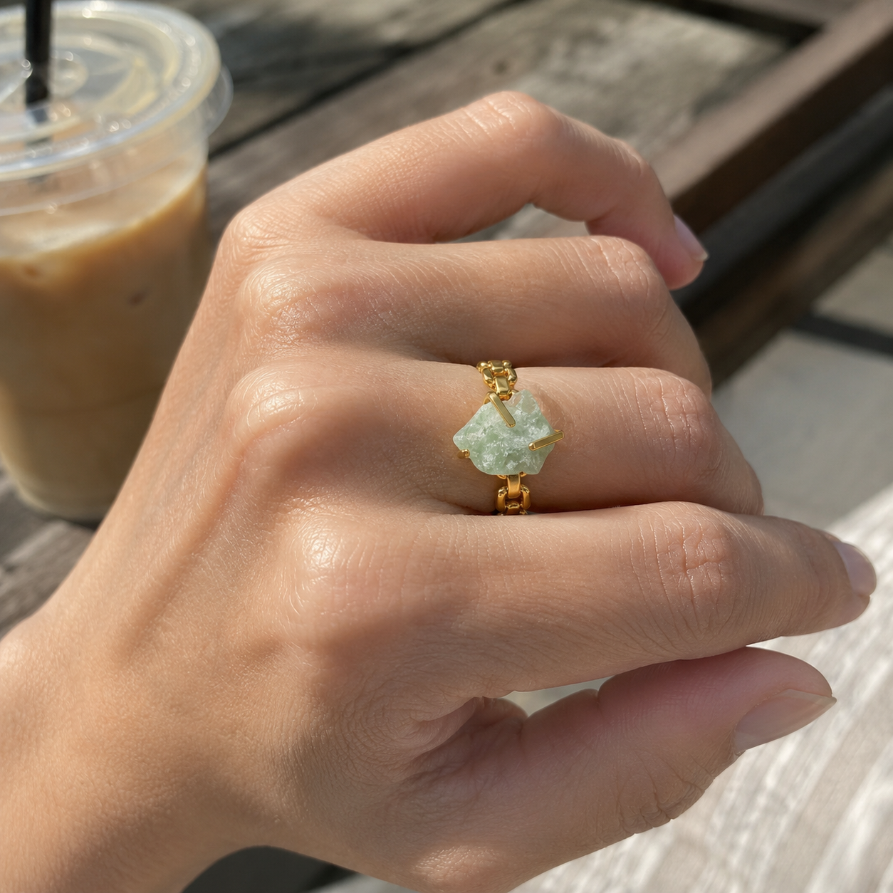 Woman wearing a gold-plated stainless steel ring with an irregular green stone