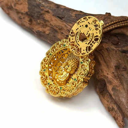 An opened sand gold locket showing a beautifully detailed baby Buddha shrine inside, displayed elegantly on natural driftwood.