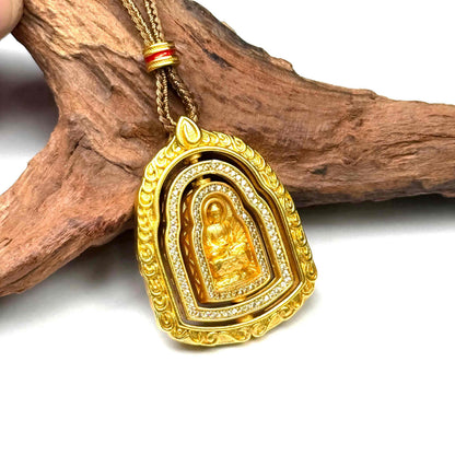 An interactive gold Buddha locket charm shown during rotation, revealing its intricately sculpted reverse side against a driftwood setting.