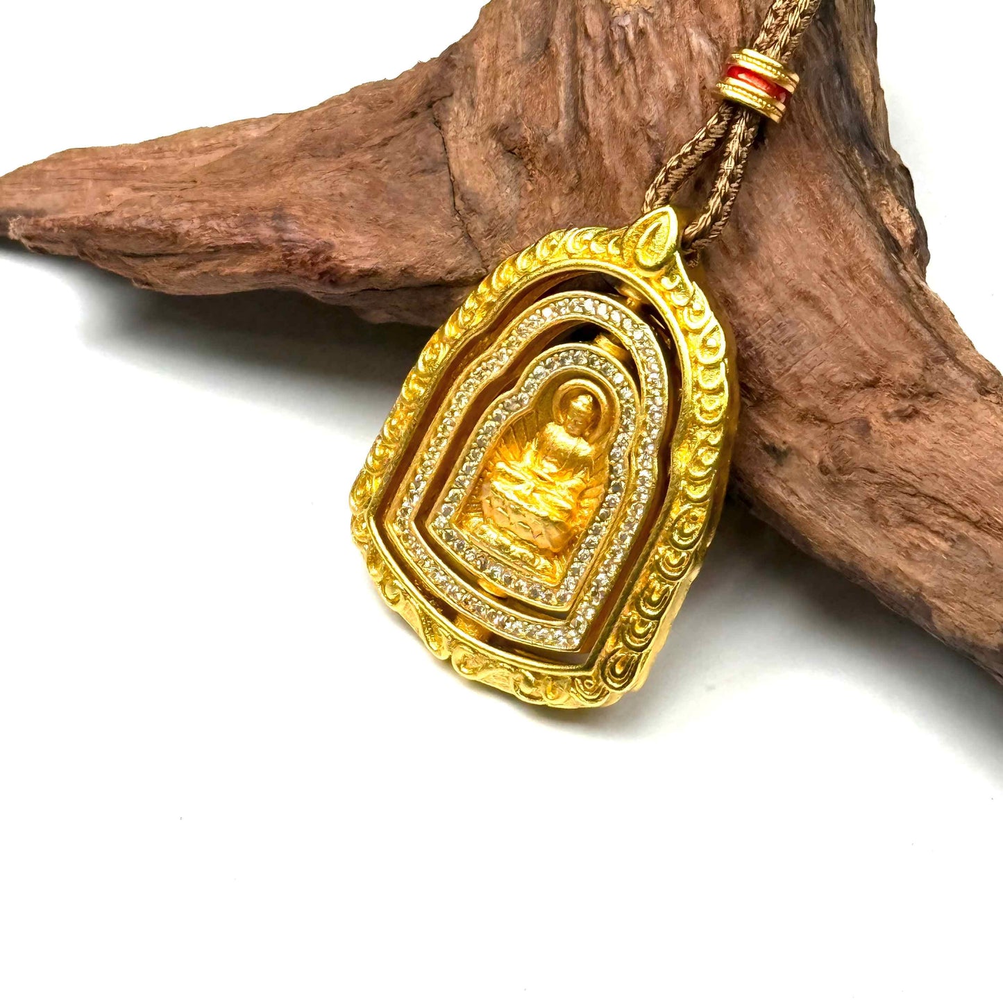 Macro top-down view of a 3D kinetic sand gold Buddha necklace spinning on wood, capturing the beautiful multi-directional rotating movement.