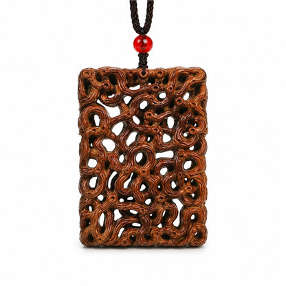 Front view of an openwork jujube wood dragon carving pendant with black braided cord