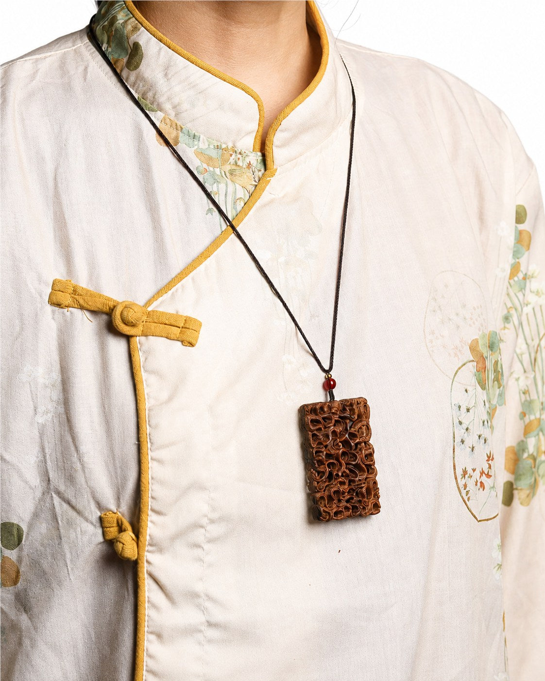 Person wearing an openwork jujube wood dragon carving pendant necklace