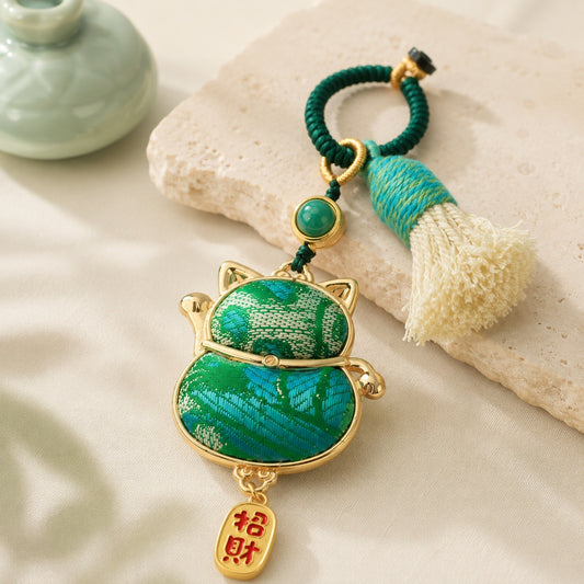 Lucky cat brocade tassel hanging charm in green with gold-tone trim and decorative tassel