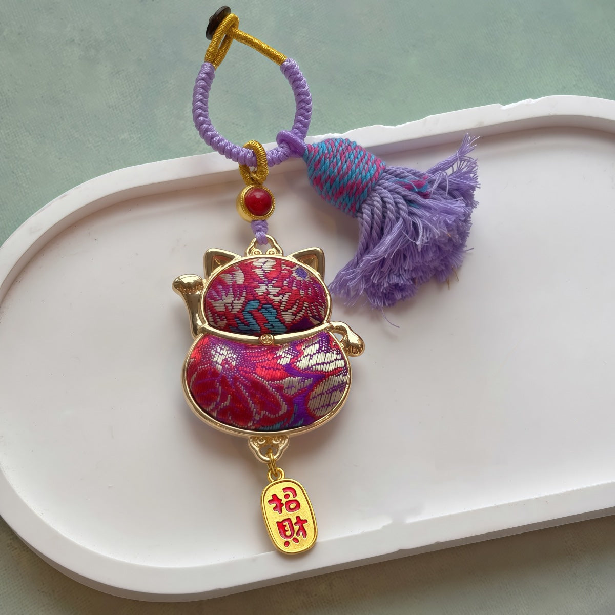 Lucky cat brocade tassel hanging charm in purple with gold-tone trim and tassel