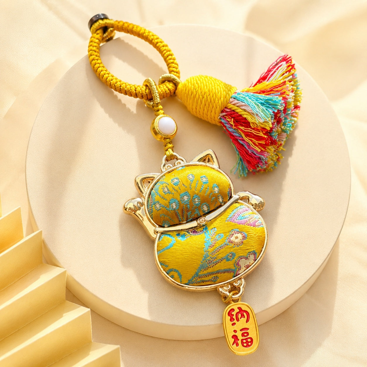 Lucky cat brocade tassel hanging charm in yellow with gold-tone trim and colorful tassel