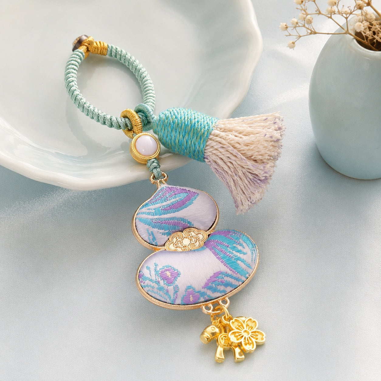Light blue brocade lucky gourd hanging charm with cotton tassel and gold-tone details