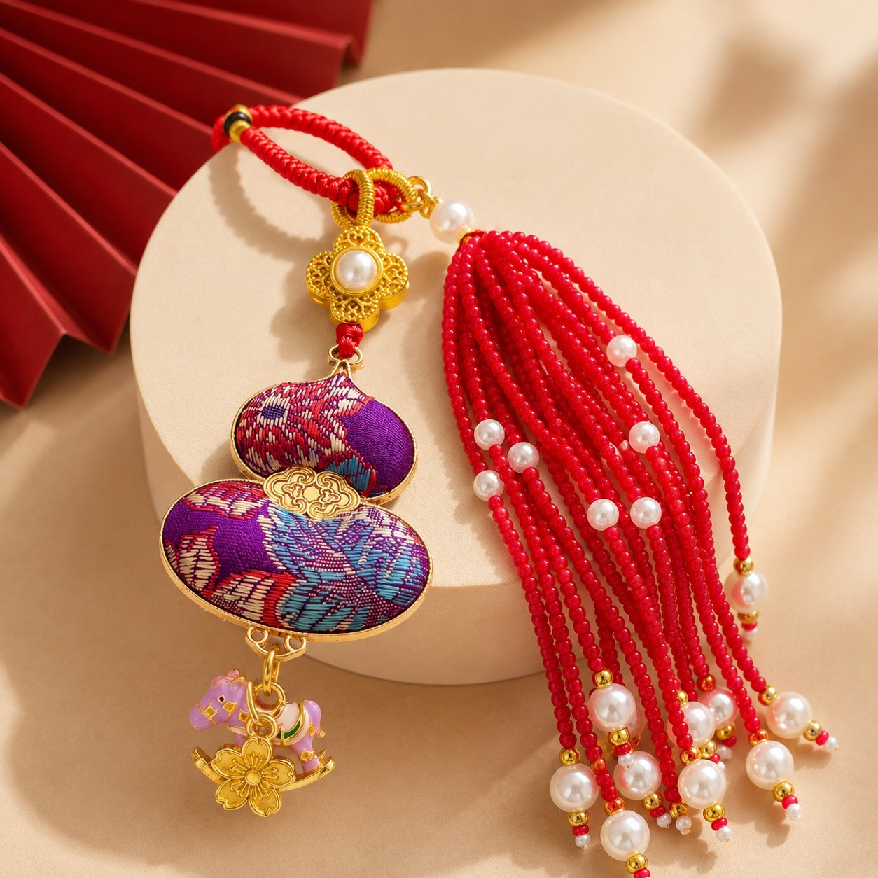 Red and purple brocade lucky gourd hanging charm with pearl tassel and gold-tone charms