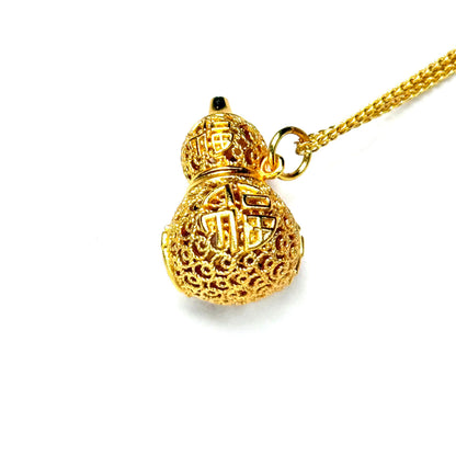 A crisp front view of an authentic sand gold Hulu gourd pendant showcasing fine imperial filigree openwork with detailed crimson and blue enamel accents on a white background.