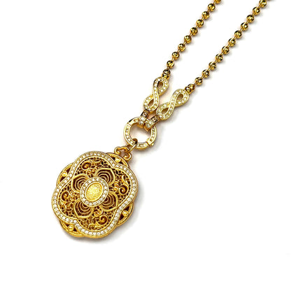An angled macro view of a heavy sand gold lotus locket pendant connected to a premium gold bead necklace chain, displayed on a pure white background.