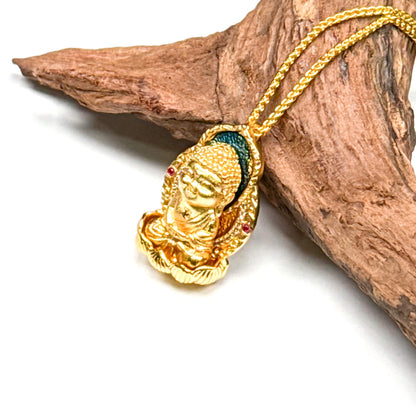 A beautiful traditional sand gold Buddha amulet necklace resting gracefully on a piece of rustic driftwood, highlighting its serene expression and detailed craftsmanship.