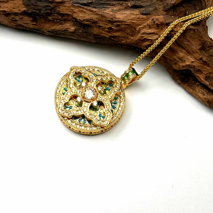 A regal sand gold sacred geometry mandala pendant with vibrant blue enamel accents and a gold wave chain, displayed elegantly against a rustic driftwood branch for a Zen look.