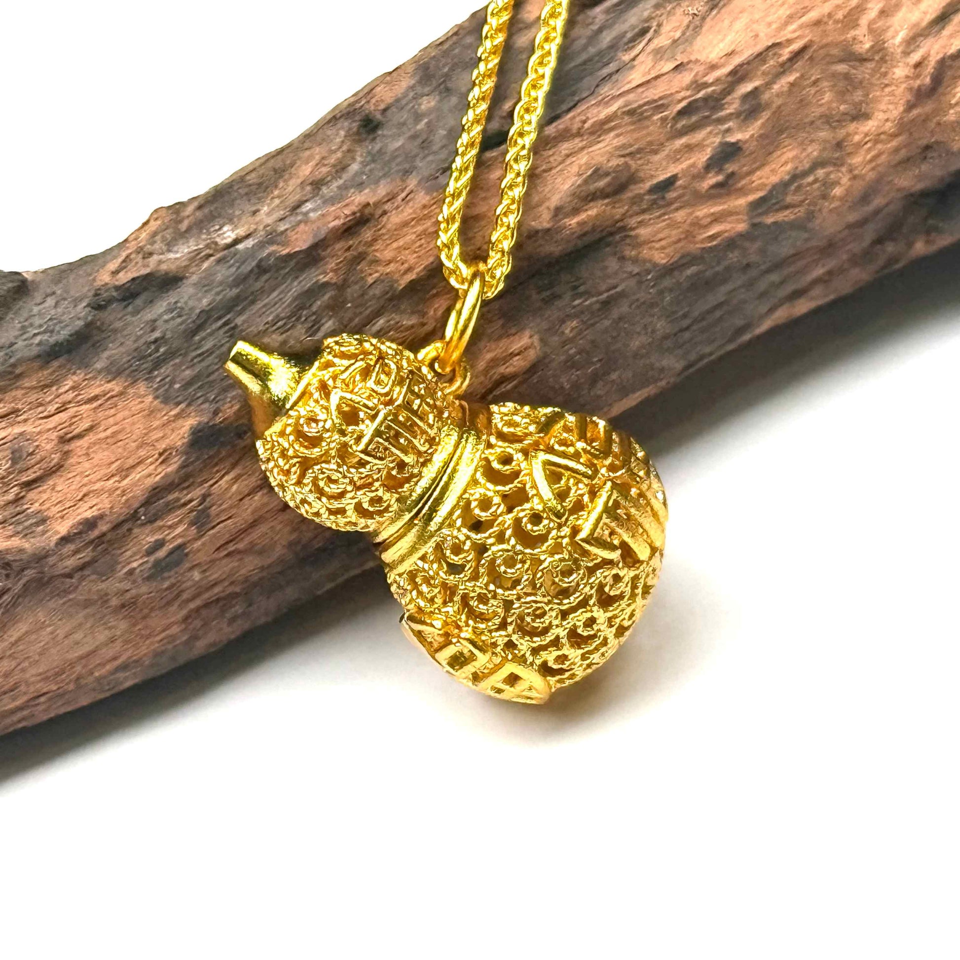 Macro close-up shot of an imperial style sand gold filigree Hulu charm on wood, capturing the flawless metal mesh weaving and vivid enamel layers.