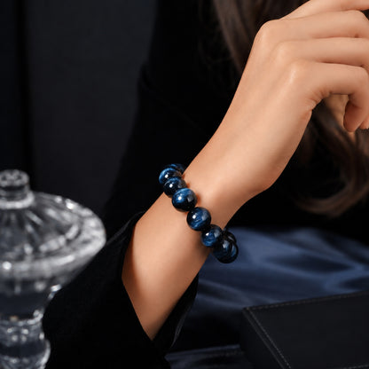 Blue tiger’s eye bracelet worn on wrist with elegant dark styling