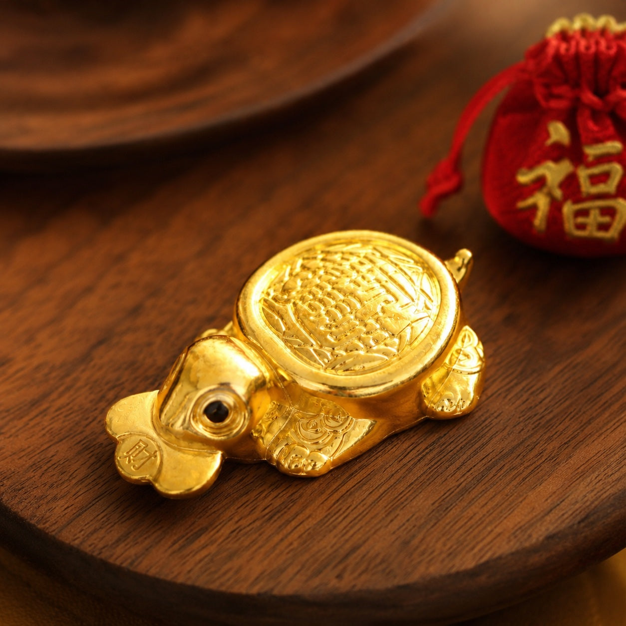 Gold-tone Money-Biting Turtle wealth figurine displayed on a wooden tray