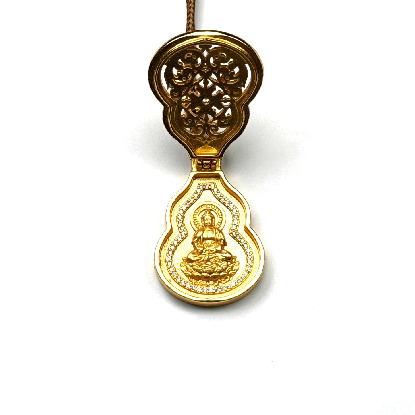 An opened sand gold gourd-shaped prayer locket (Gau box) revealing a hidden golden seated Buddha inside with a radiant background.