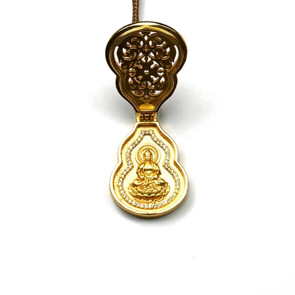 An opened sand gold gourd-shaped prayer locket (Gau box) revealing a hidden golden seated Buddha inside with a radiant background.