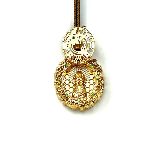 An opened sand gold circular prayer locket revealing a hidden golden seated child Buddha inside with a sparkling rhinestone halo.