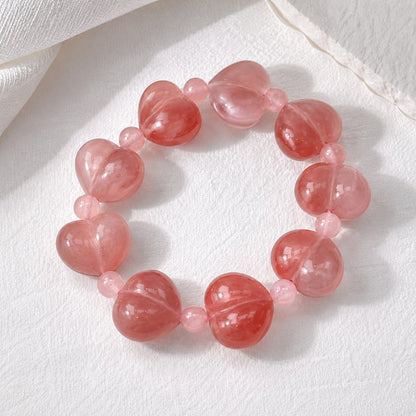 Pink quartzite jade heart bead bracelet on a white textured background