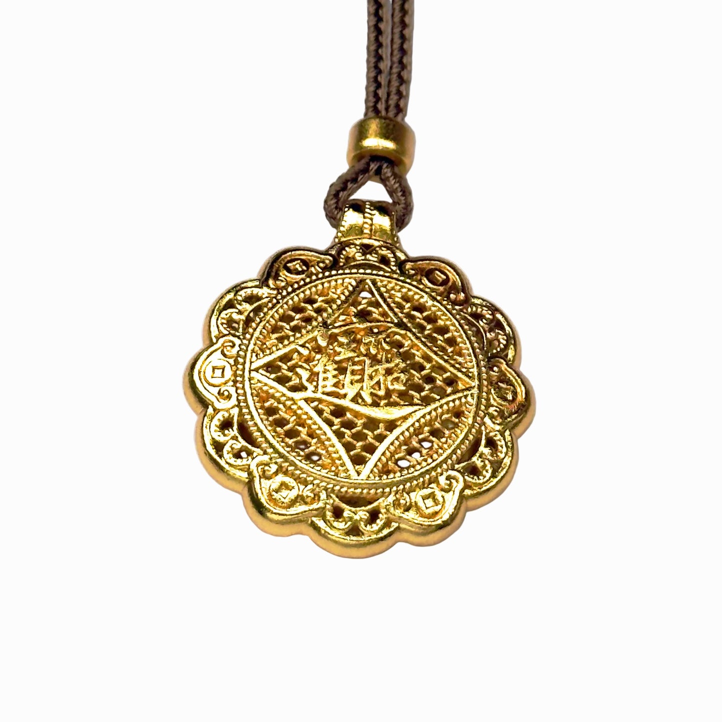 The reversible back side of a sand gold charm, showcasing deeply engraved Chinese characters for bringing in wealth and treasures on a delicate filigree mesh background.
