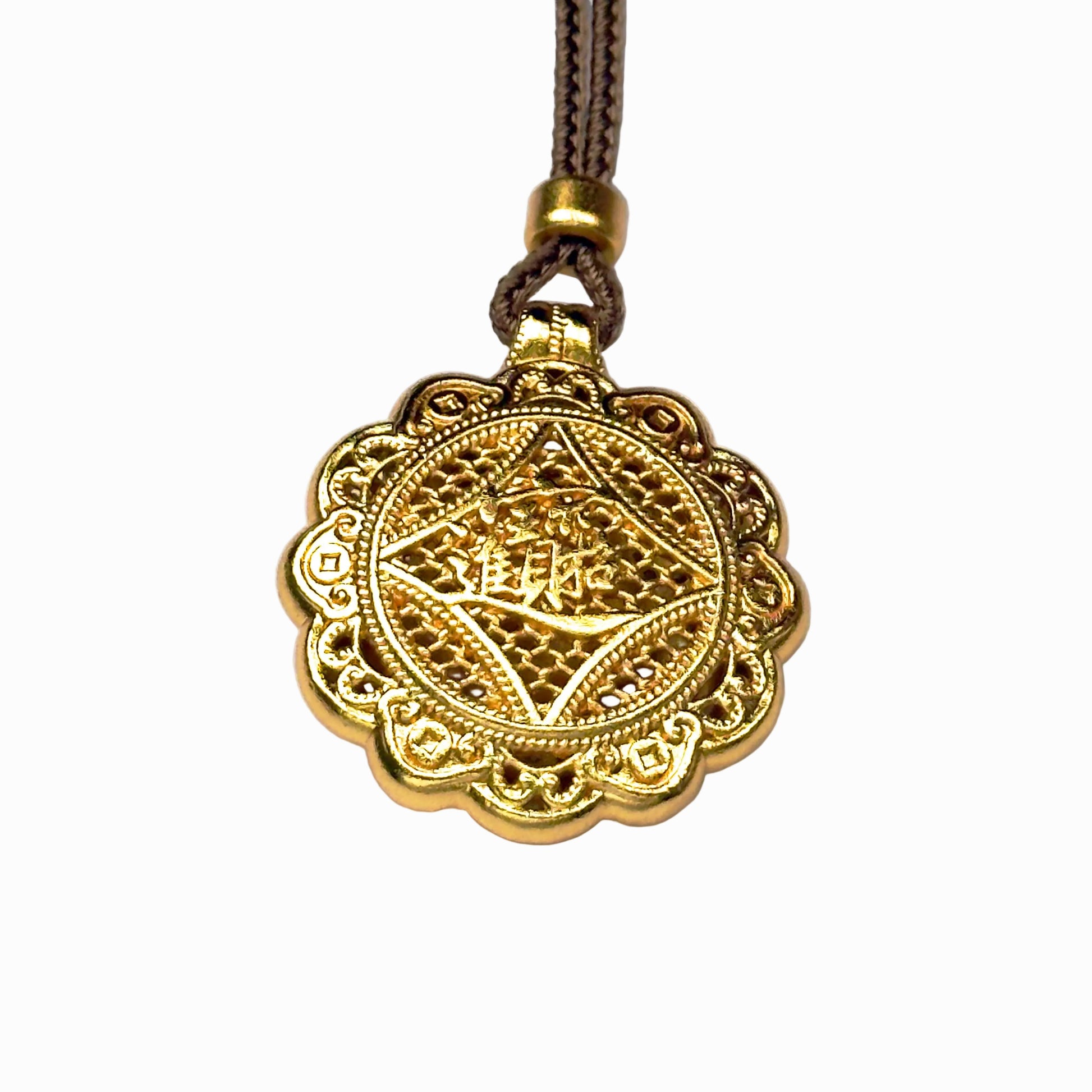 The reversible back side of a sand gold charm, showcasing deeply engraved Chinese characters for bringing in wealth and treasures on a delicate filigree mesh background.
