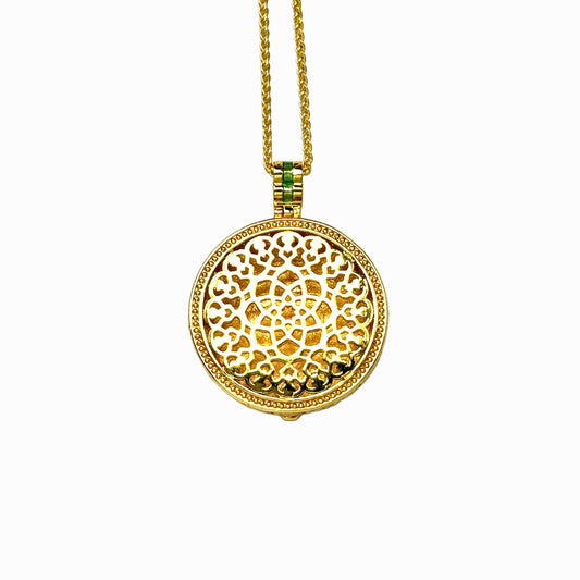 The reversible back side of a round gold medallion necklace, showcasing a smooth brushed finish with an intricate Chinese openwork foliage lattice pattern on a white background.