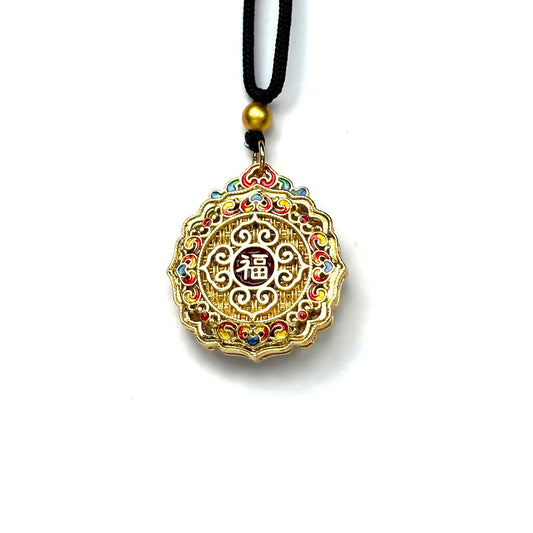 The reversible back side of a sand gold fortune charm necklace, showcasing a central red enamel "Fu" blessing character framed by intricate golden filigree and colorful accents.