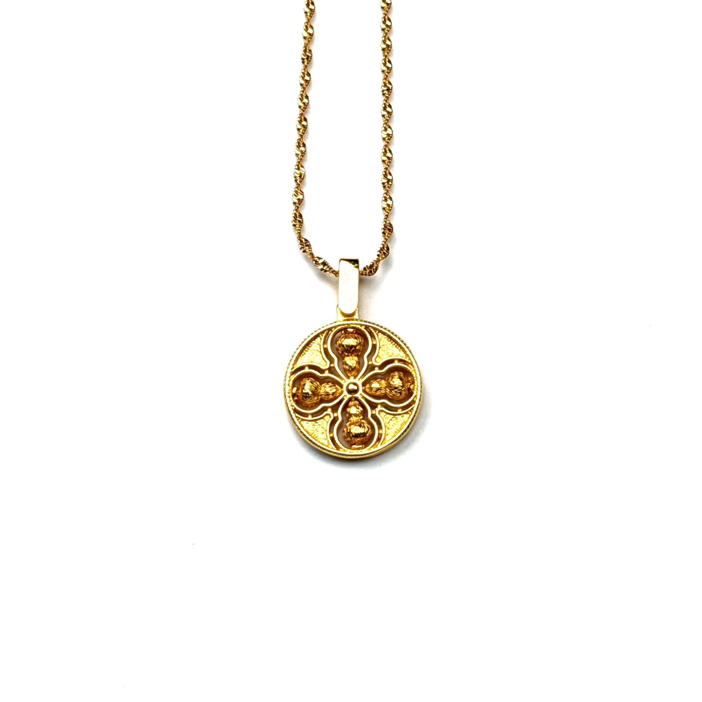 The reversible brushed back side of a sand gold Tibetan Vajra amulet necklace, showcasing a minimalist all-gold openwork design on a white background.