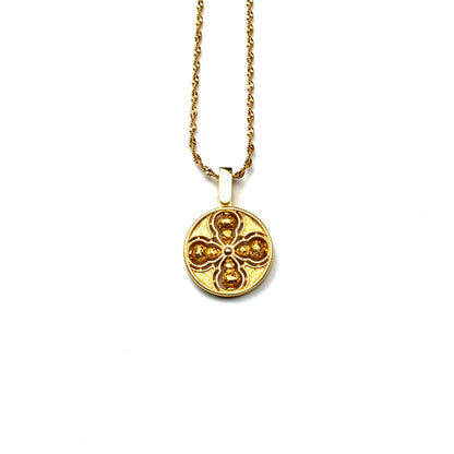 The reversible brushed back side of a sand gold Tibetan Vajra amulet necklace, showcasing a minimalist all-gold openwork design on a white background.