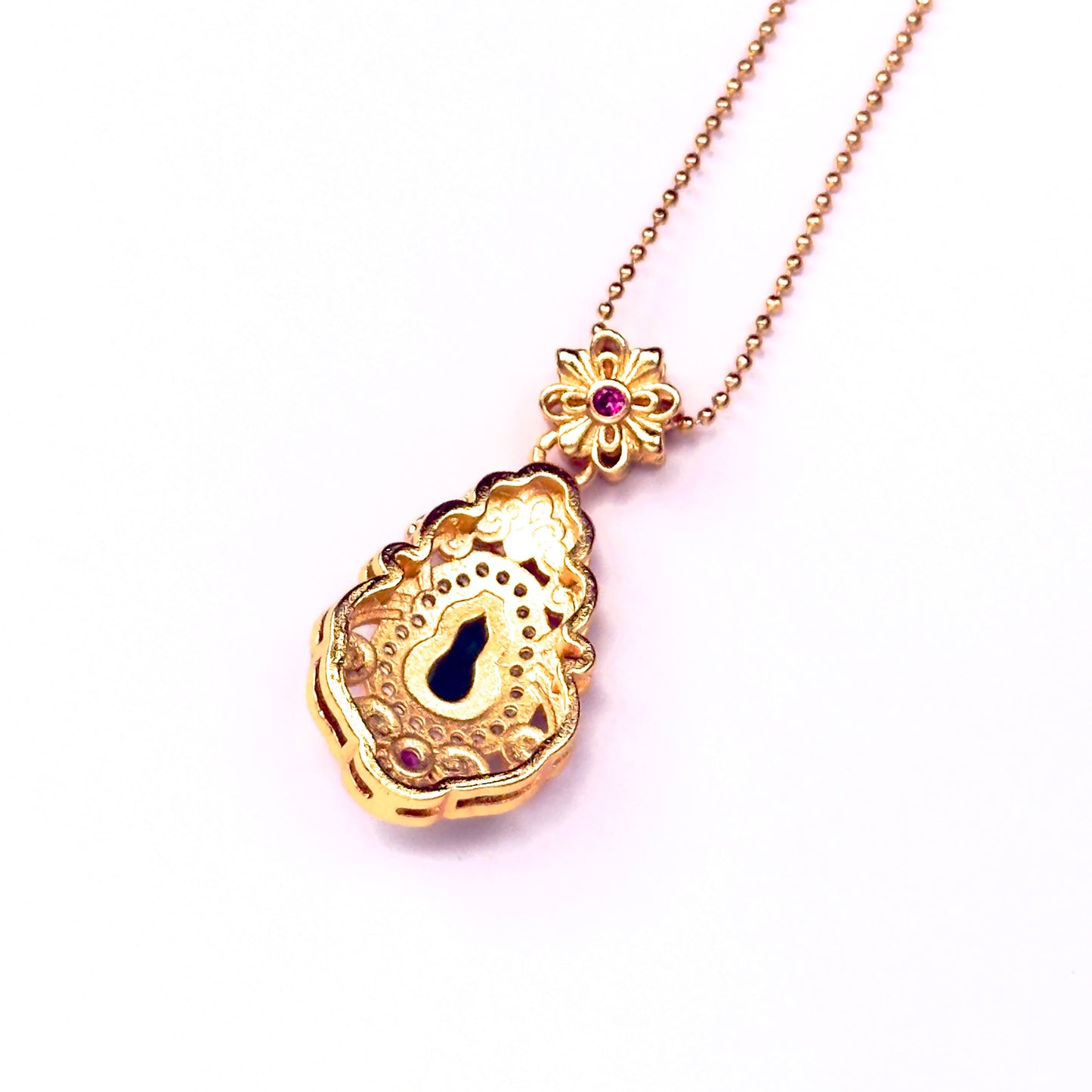 The reversible back side of a sand gold gourd necklace, showcasing a smooth all-gold brushed finish with a unique hollow cut-out gourd light window at the center.
