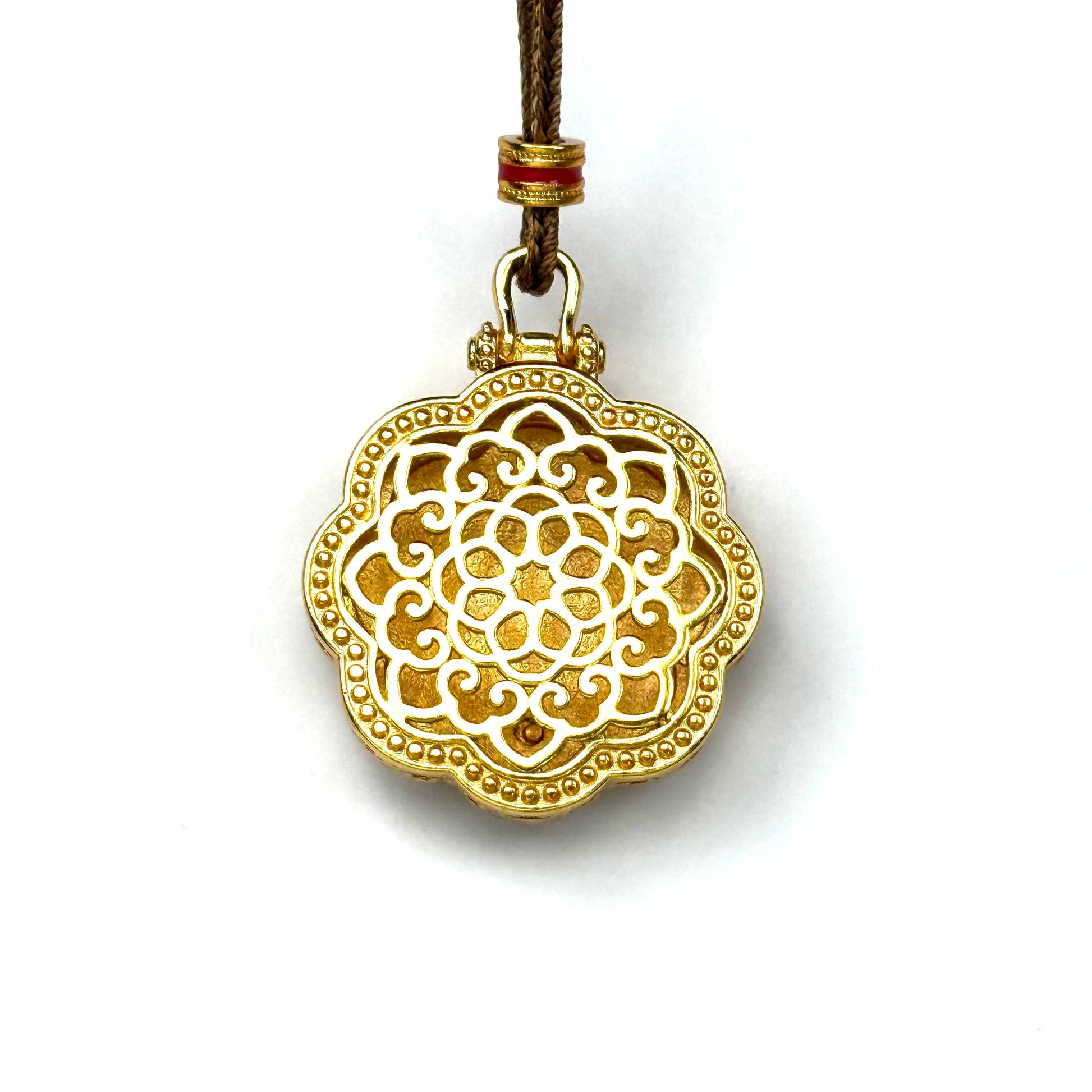 The detailed back view of a sand gold rotating pendant, showcasing a magnificent all-gold embossed Kalachakra wheel mandala pattern on a white background.